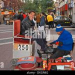 zapatos-zapatos-de-pulido-shiner-riendo-cliente-ahumada-en-el-bullicioso-centro-comercial-en-la-ciudad-de-santiago-de-chile-dkgr4g